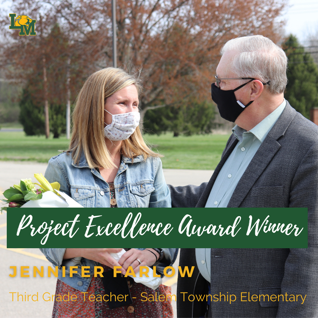 Superintendent Power hands flowers to teacher