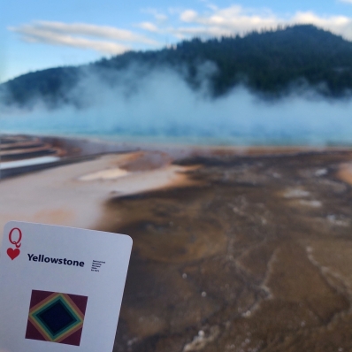 playing card in front of a geyser at Yellowstone