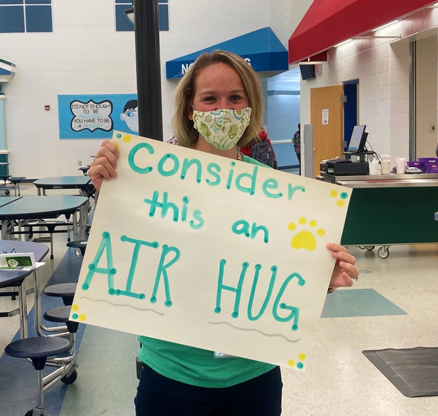LMIS Staff member with a sign that reads: Consider this an air hug!